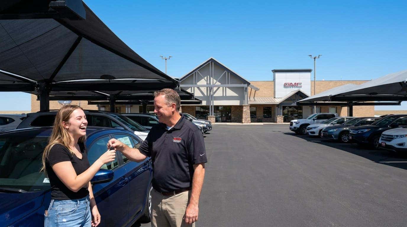 Young first-time car buyer receiving keys to a used vehicle at Weld County Garage in Greeley, Northern Colorado