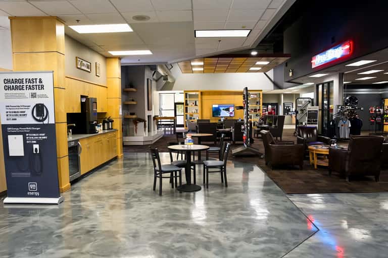The customer lounge at Weld County Garage with seating, a coffee bar and a device charging station