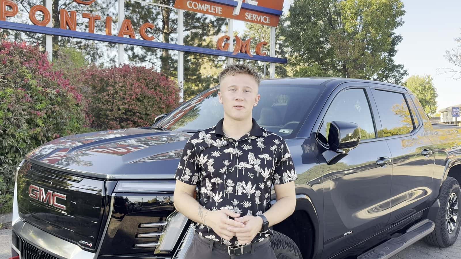 Everett from Weld County Garage GMC in front of a 2026 GMC Sierra EV AT4 in Greeley, Colorado